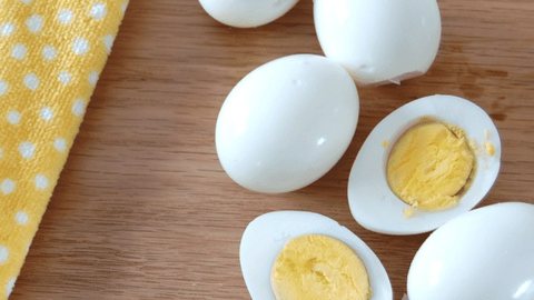 Peeled hard-boiled eggs, some halved to show the yolk